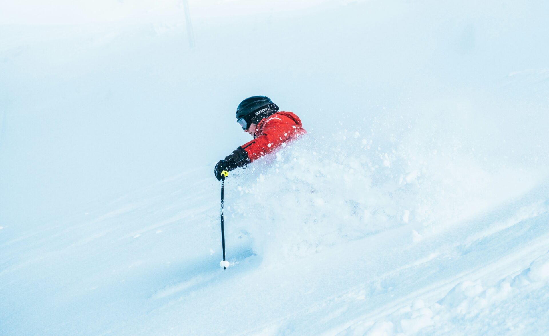 Skier in a red jacket and black helmet