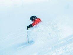 Skier in a red jacket and black helmet