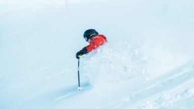 Skier in a red jacket and black helmet