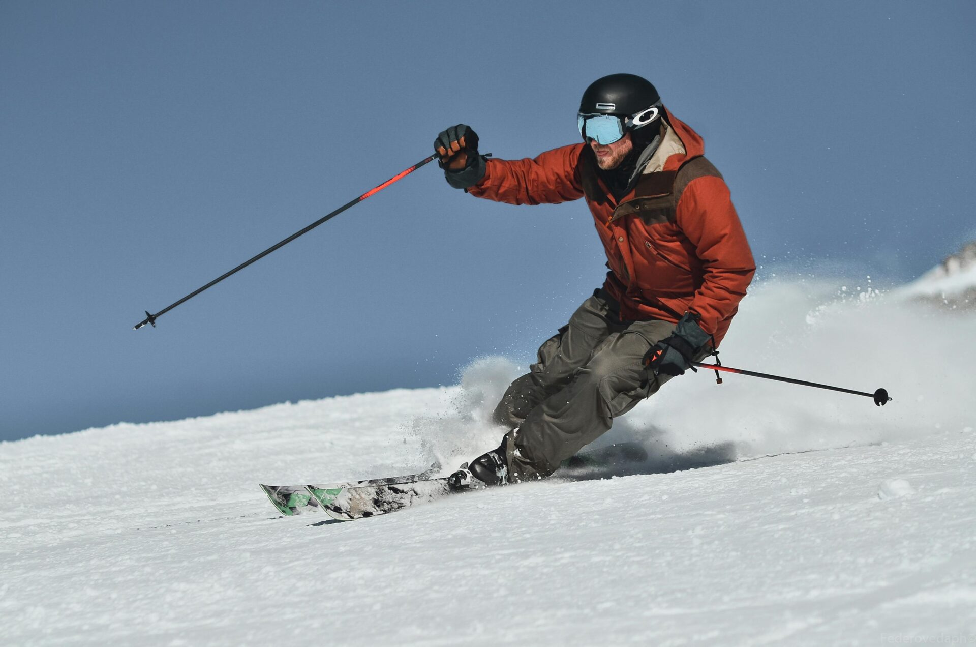 Skier in orange jacket and gray pants