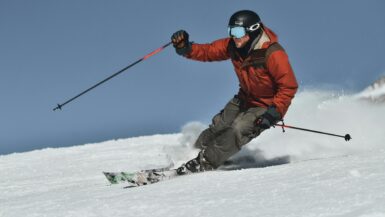 Skier in orange jacket and gray pants