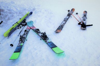 Pairs of skis laying on the ground