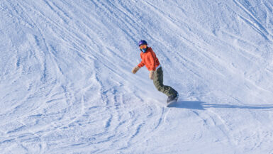 orange jacket snowboarder