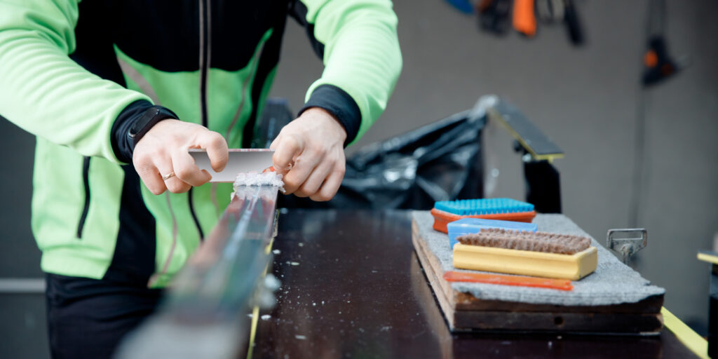 ski repair technician waxing skis