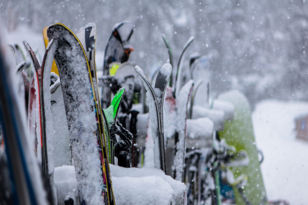 snowy skis on ski rack