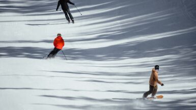 Skiers and a snowboarder