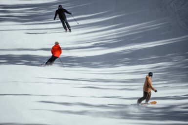 Skiers and a snowboarder